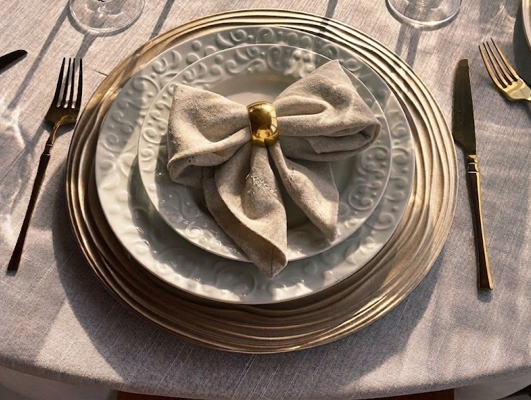Detalhe de prato com guardanapo em laço dourado